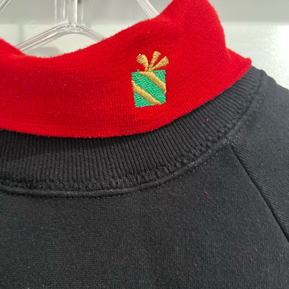 Black turtleneck sweatshirt with embroidered present